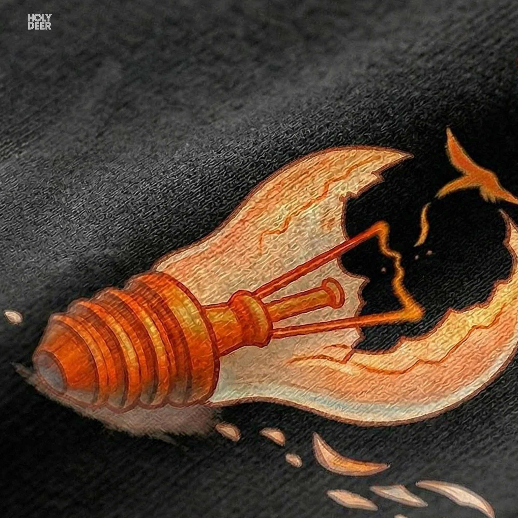 Macro view of the Freedom Tshirt print showcasing intricate line art on the shattering glass edges, glowing orange bulb filament, and fine micro bird silhouettes crafted exclusively by Holydeer Streetwear.