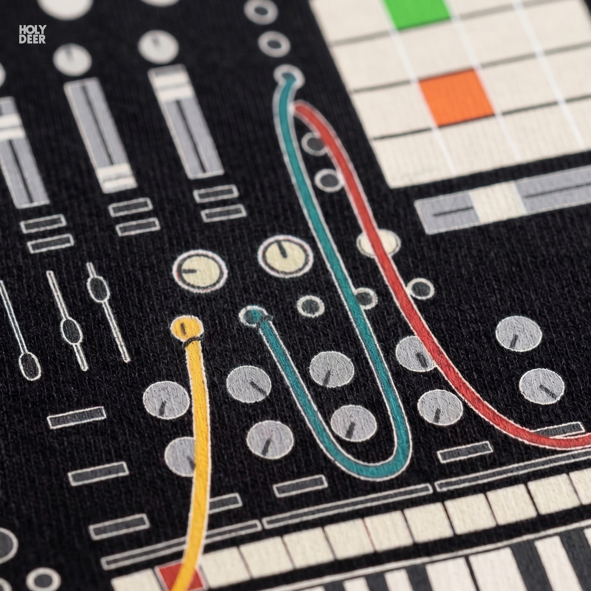 Macro view of the Modular Synth Tee print showcasing intricate wireframe routing lines, colorful yellow and turquoise patch cords, and fine retro synth design points crafted exclusively by Holydeer Streetwear.