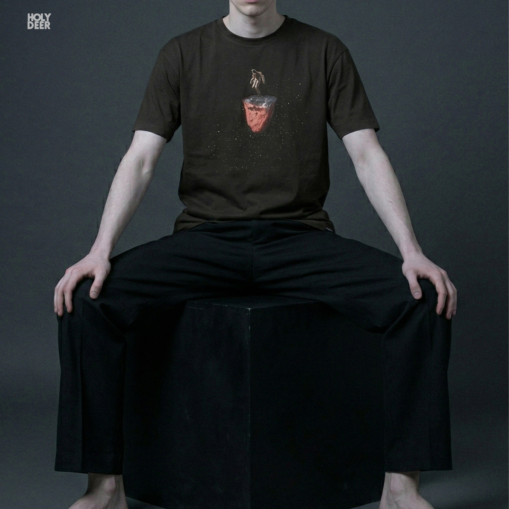 Industrial warehouse rave architecture outdoor lifestyle model wearing the centered Techno Rave Tshirt from Holydeer Clothing, standing as a high-end techno dj tshirt statement matching elite club dj shirt trends.