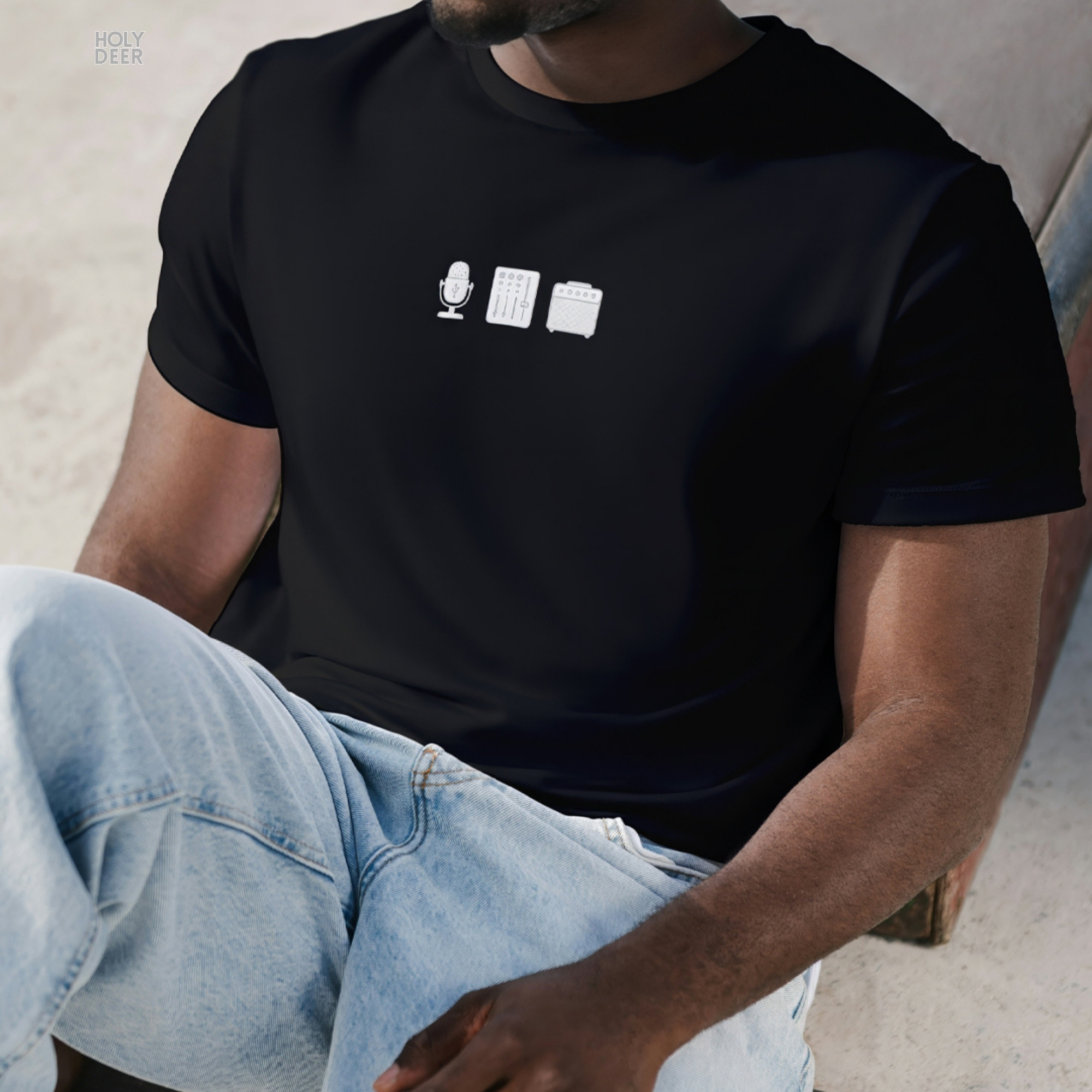 Technical side perspective tracking the parallel thread runs along the lower waist seam and hem fold of the unisex black music shirt.