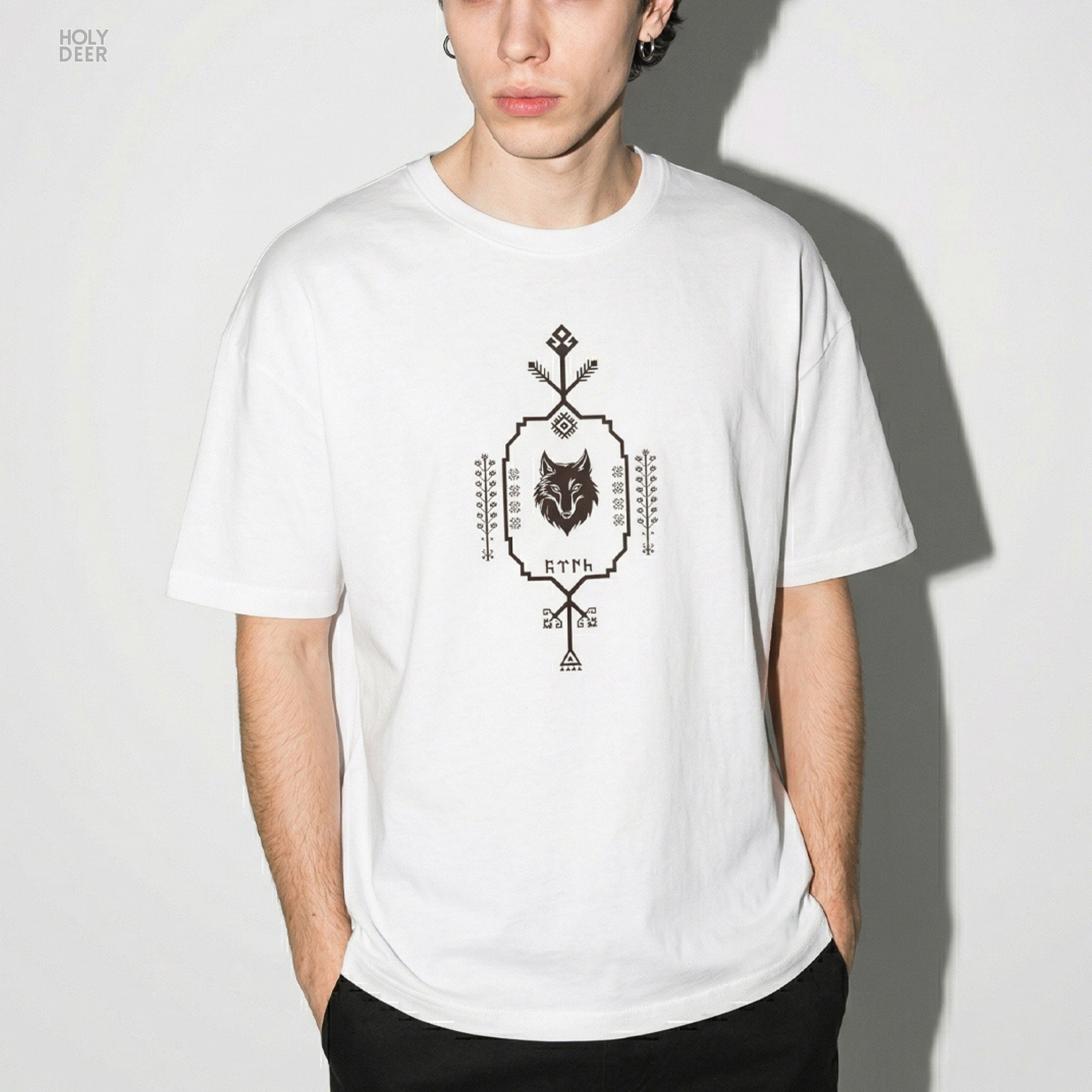 Technical close-up highlighting the arrow directions, miniature branch segments, and cross-hatched diamond shapes forming the peak of the nomad symbol tee print.