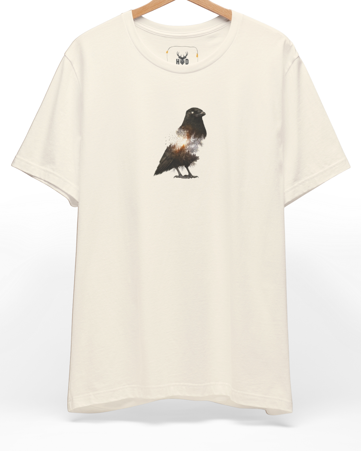 An eye-level studio presentation highlighting the crow-tshirt-dark-aesthetic-raven-graphic-minimal-design-glowing-core-fragmented-body-holydeer-inspired.jpg artwork off-centered on a premium combed cotton canvas by Holydeer Clothing.