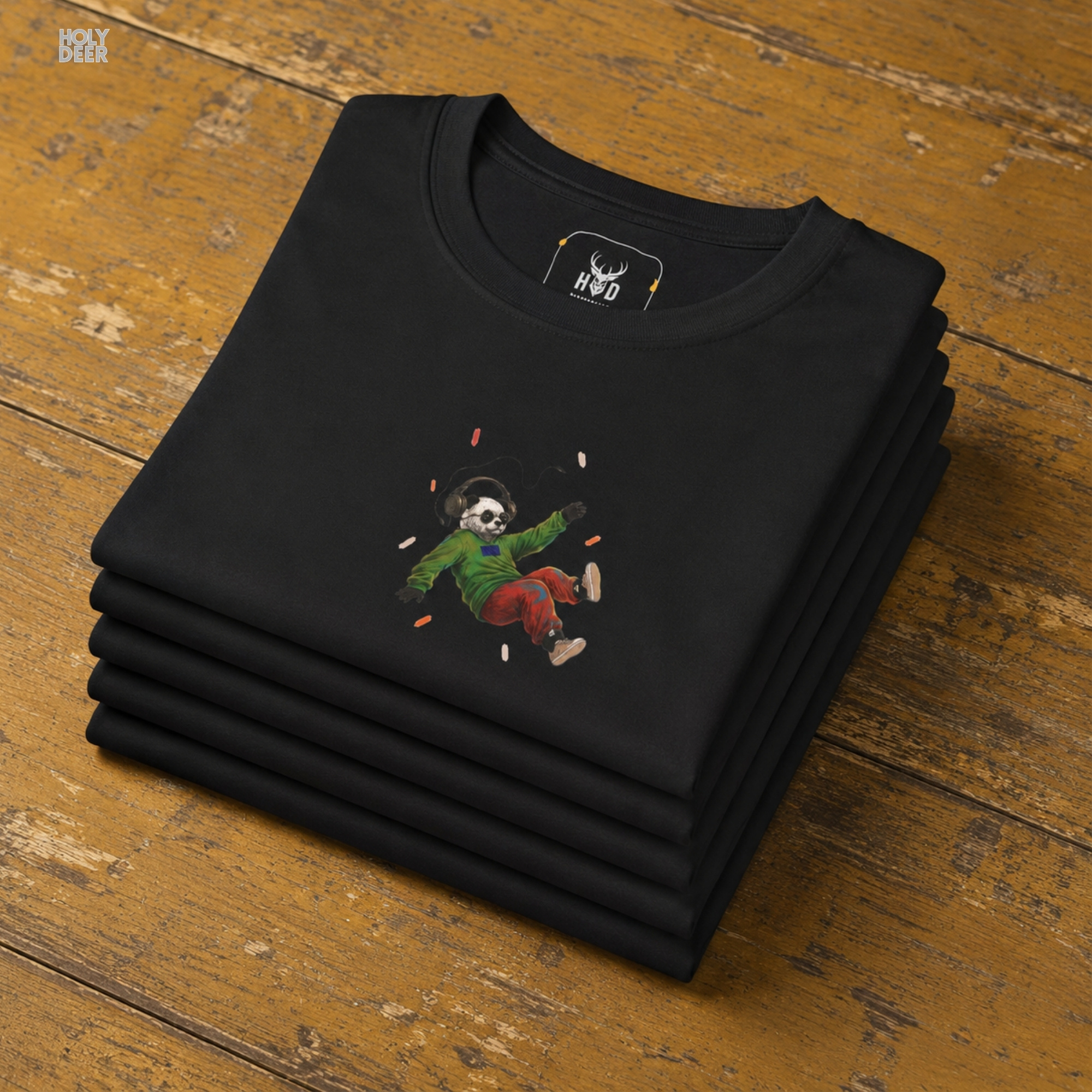 Professional flat lay photography of the Music Panda Tee by Holydeer Apparel, arranged neatly next to retro vinyl gift accessories and high-end surreal music tee sketchbooks.
