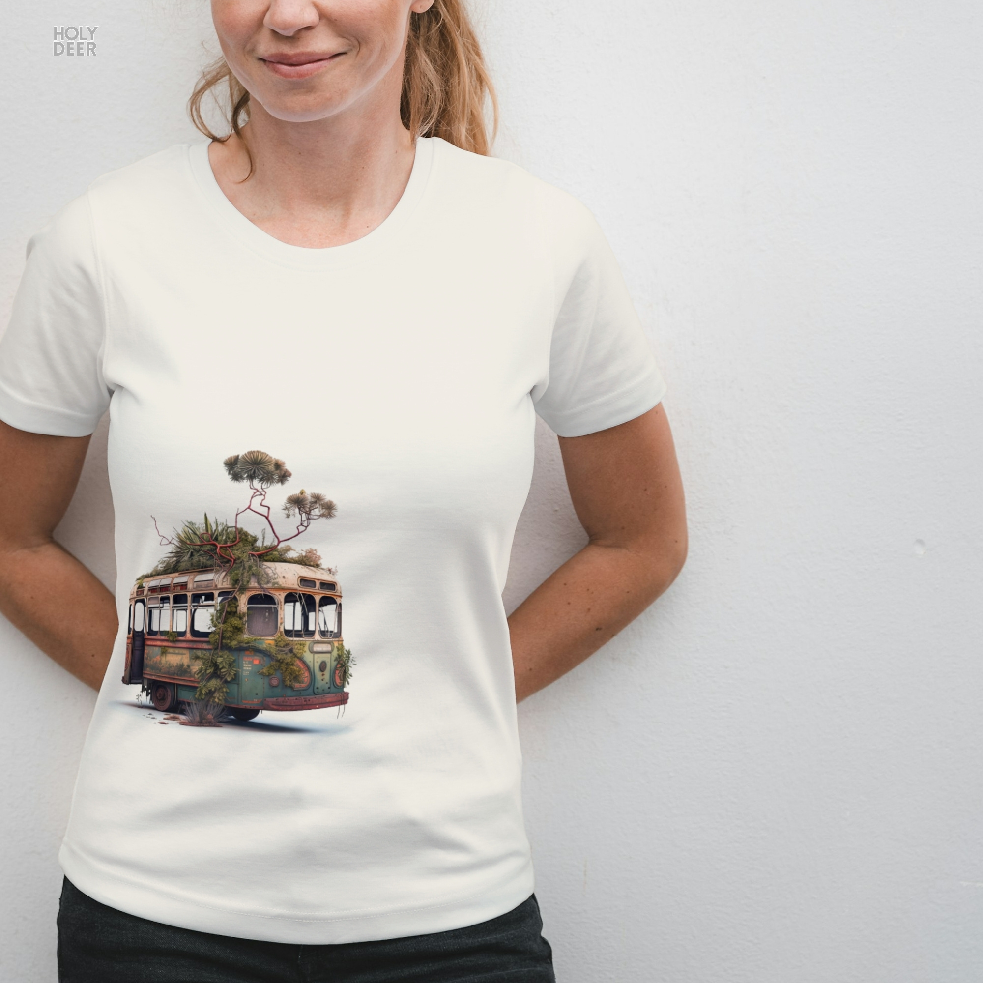 Professional flat lay photography of the Surreal Bus Tee by Holydeer Apparel, arranged cleanly next to real preserved green moss patches, tarnished brass railway tokens, and story graphic tee lifestyle essentials.