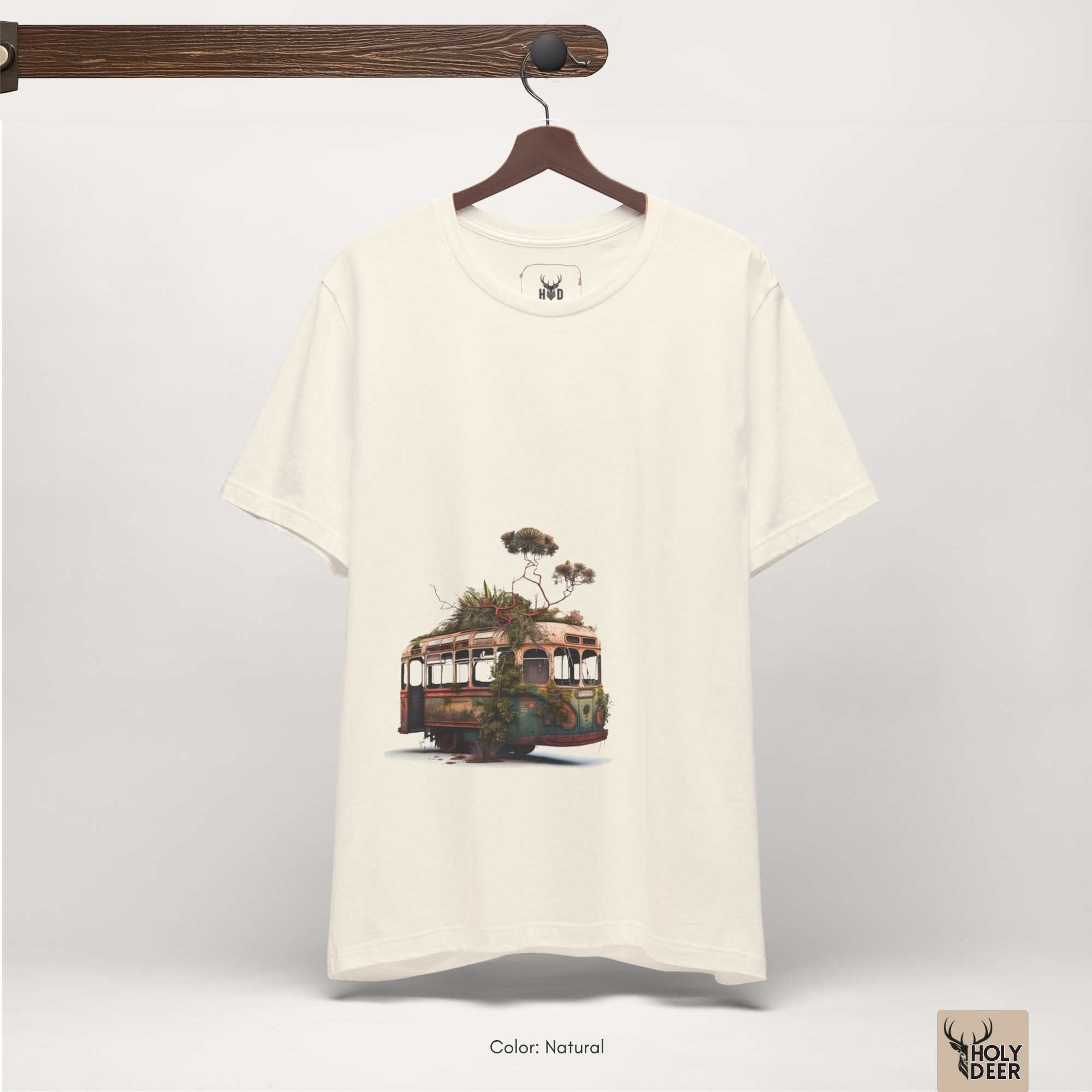 Angled perspective of the premium screen-printed Surreal Bus Tee, detailing the thick paint feel of the retro vehicle skeleton layout and erupting canopy tree branches, center-bottom layout placement, and the signature holydeer tee high-contrast design.