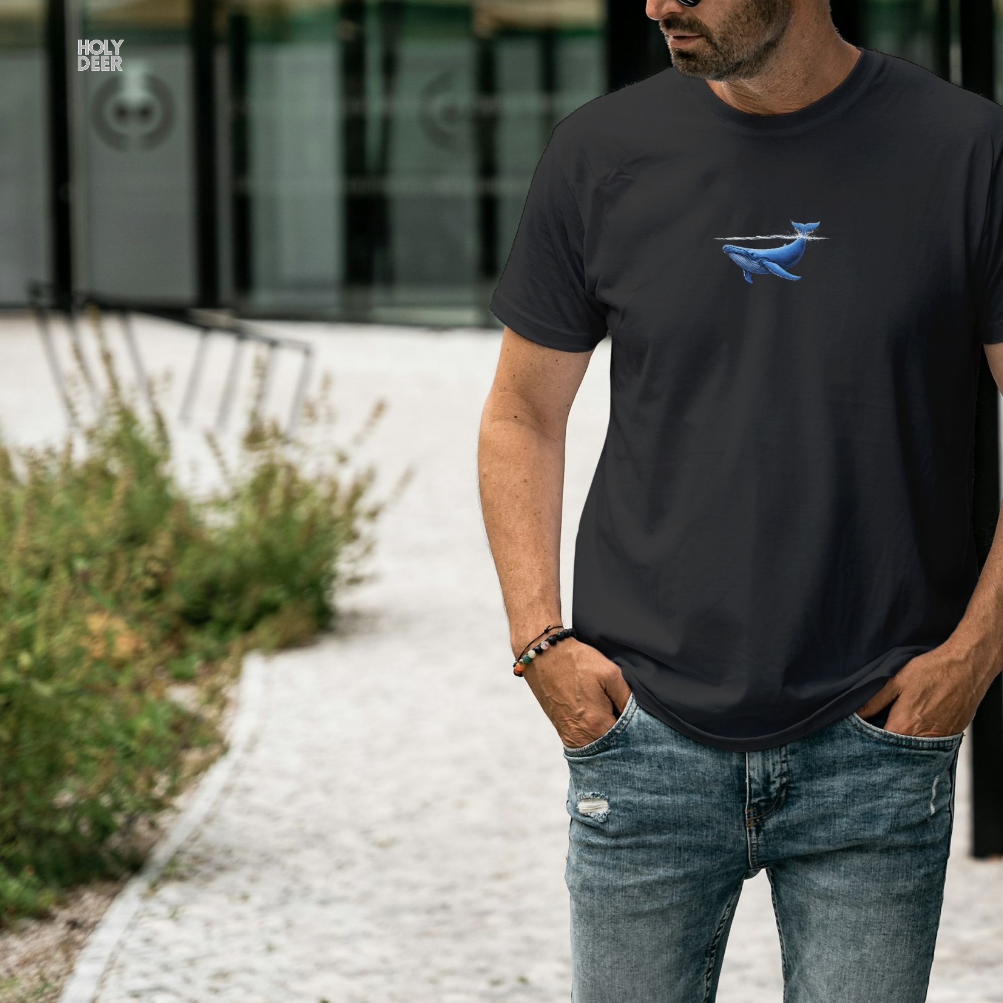 A top-down lifestyle layout featuring the whale gift tee neatly folded next to deep blue metamorphic minerals and rough oceanic crystal blocks.