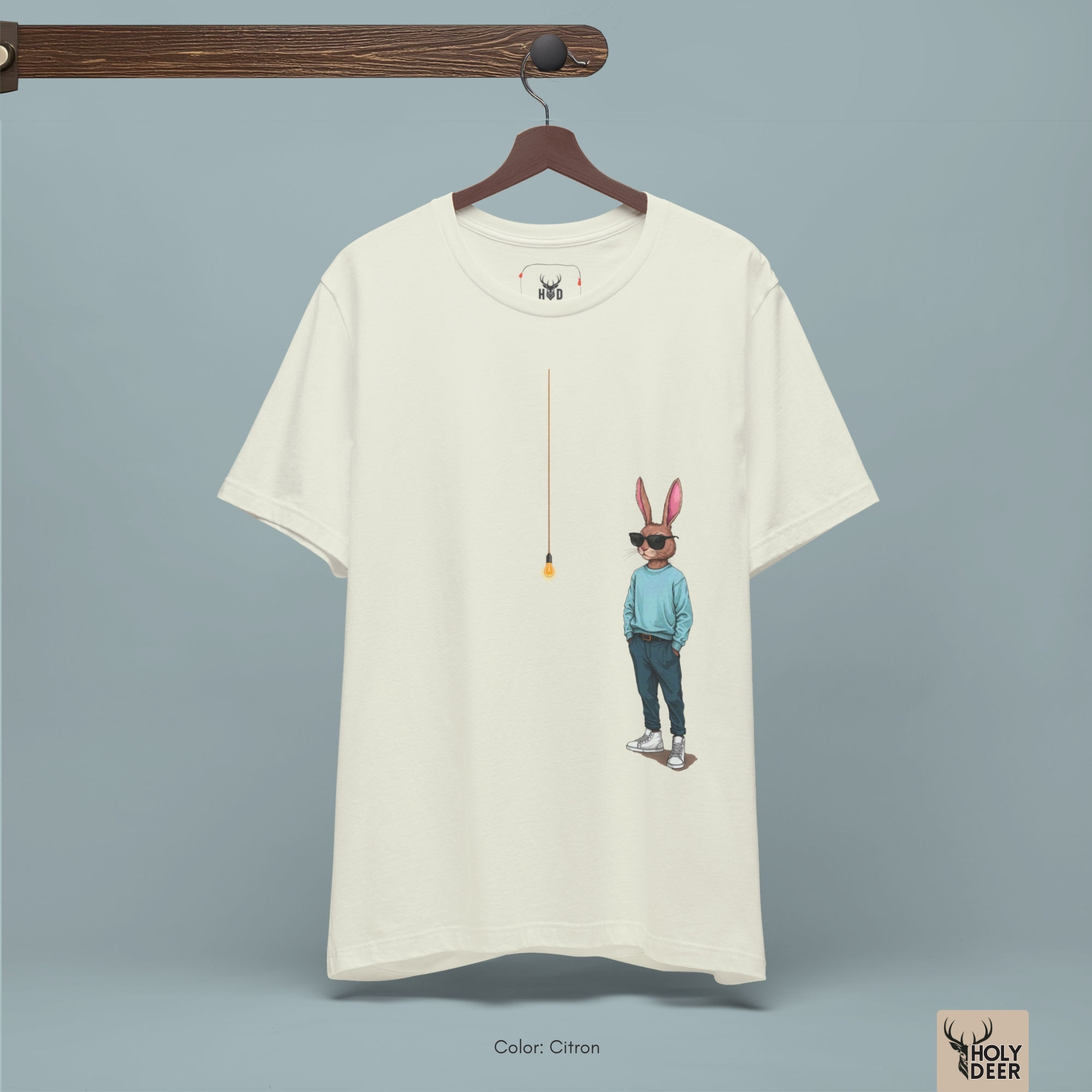 Soft amber shadow studio backdrop framing the unique Cool Rabbit Shirt by Holydeer Streetwear, magnifying the clean off-centered lightbulb graphic placement and premium modern graphic tee presentation.