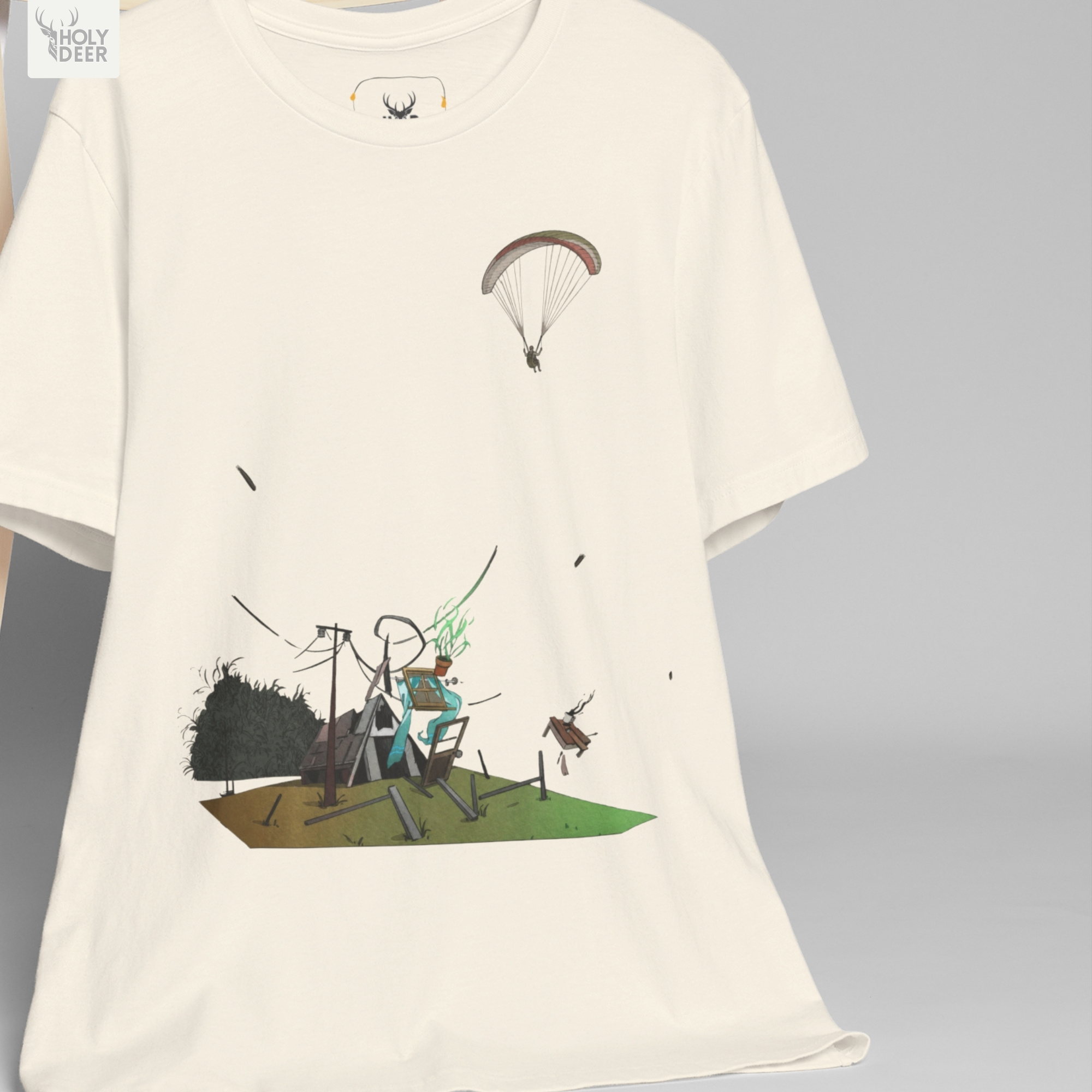 The iconic Paragliding Tee hanging cleanly on a luxury wood hanger, highlighting the robust neckline structure, paraglider shirt graphic flow, and the official holydeer.com retail tags.
