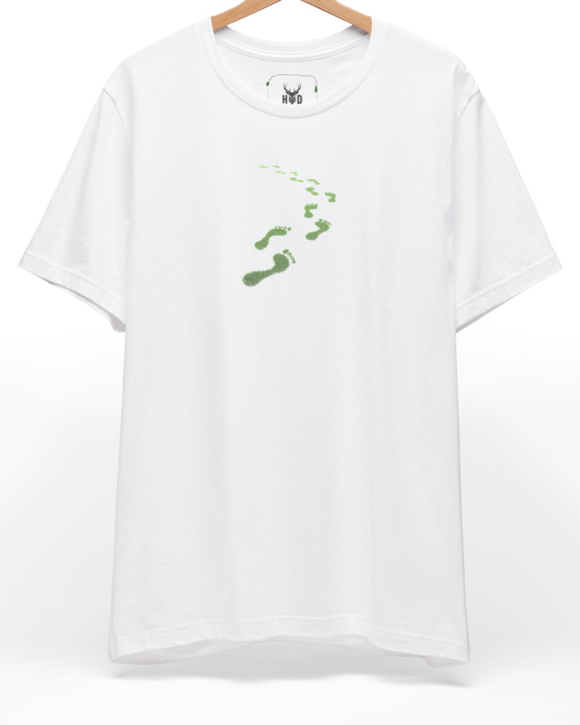 A high-end display of the official Holydeer Green Steps Shirt showcasing unique Sükûnet Veren Minimalist Green Tee design lines. The central Save The Planet Top graphic features a miniature Conscious Path Top layout centering a detailed Leaf Footprints Tee portrait with intricate green moss growths and eco activist t-shirt textures printed squarely on a white shirt canvas.