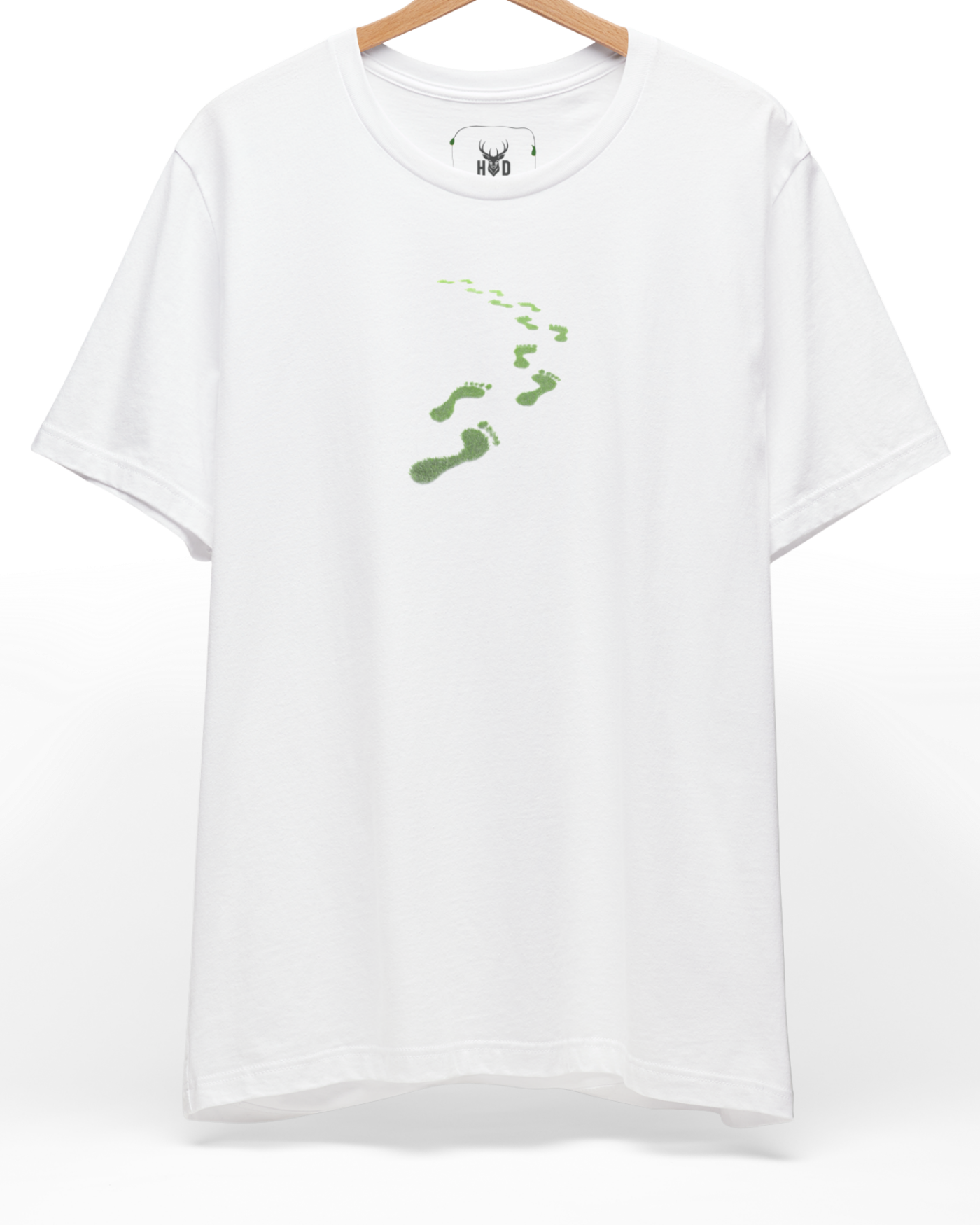 A high-end display of the official Holydeer Green Steps Shirt showcasing unique Sükûnet Veren Minimalist Green Tee design lines. The central Save The Planet Top graphic features a miniature Conscious Path Top layout centering a detailed Leaf Footprints Tee portrait with intricate green moss growths and eco activist t-shirt textures printed squarely on a white shirt canvas.