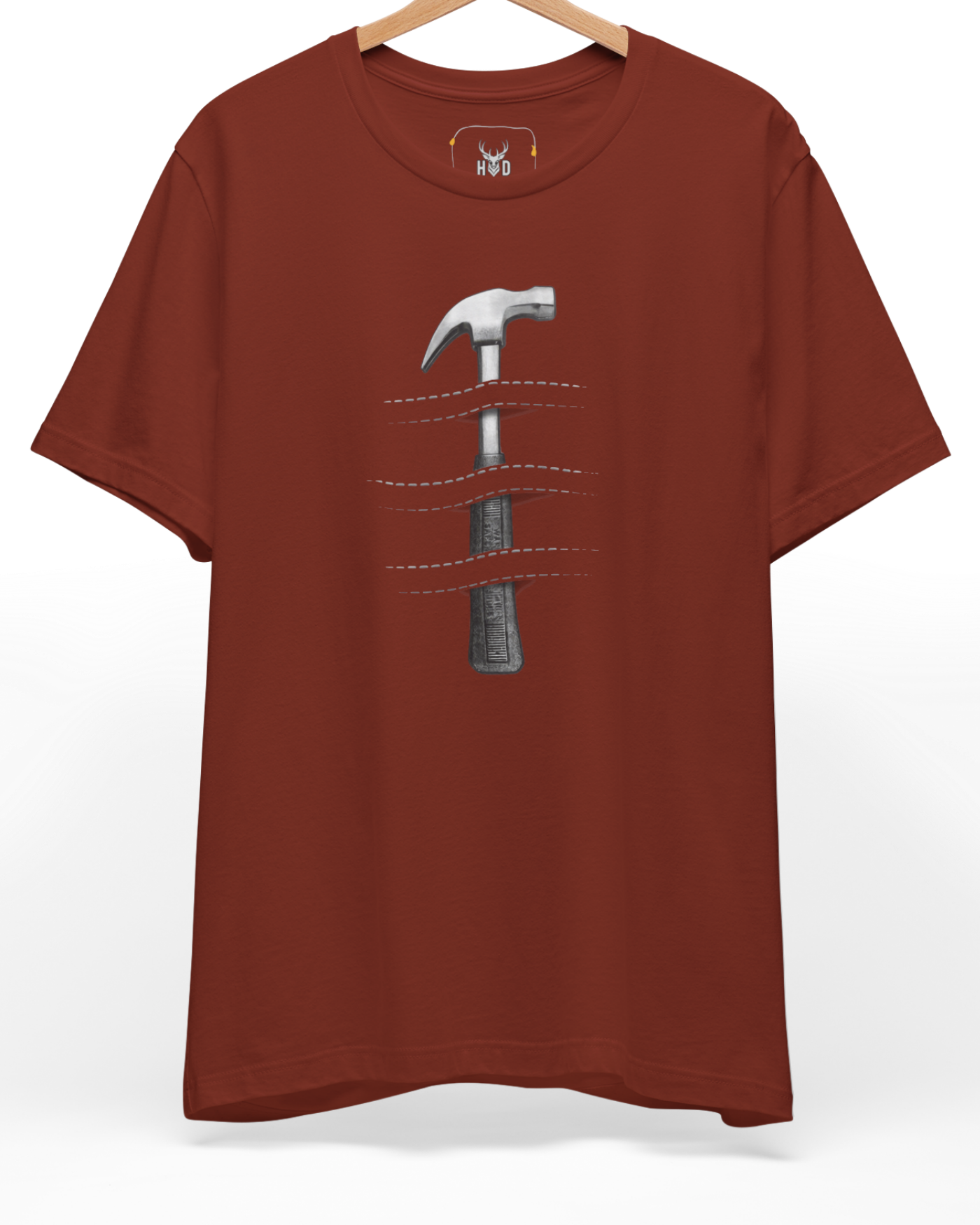 A high-end display of the official Holydeer Hammer Graphic Tee showcasing unique Industrial Apparel design lines. The central Craftsman Gift graphic features a miniature Creative Tools T layout centering a detailed Minimalist Hammer piece piercing an Optical Illusion T pattern with dashed stitch cuts printed squarely on a rust shirt canvas.