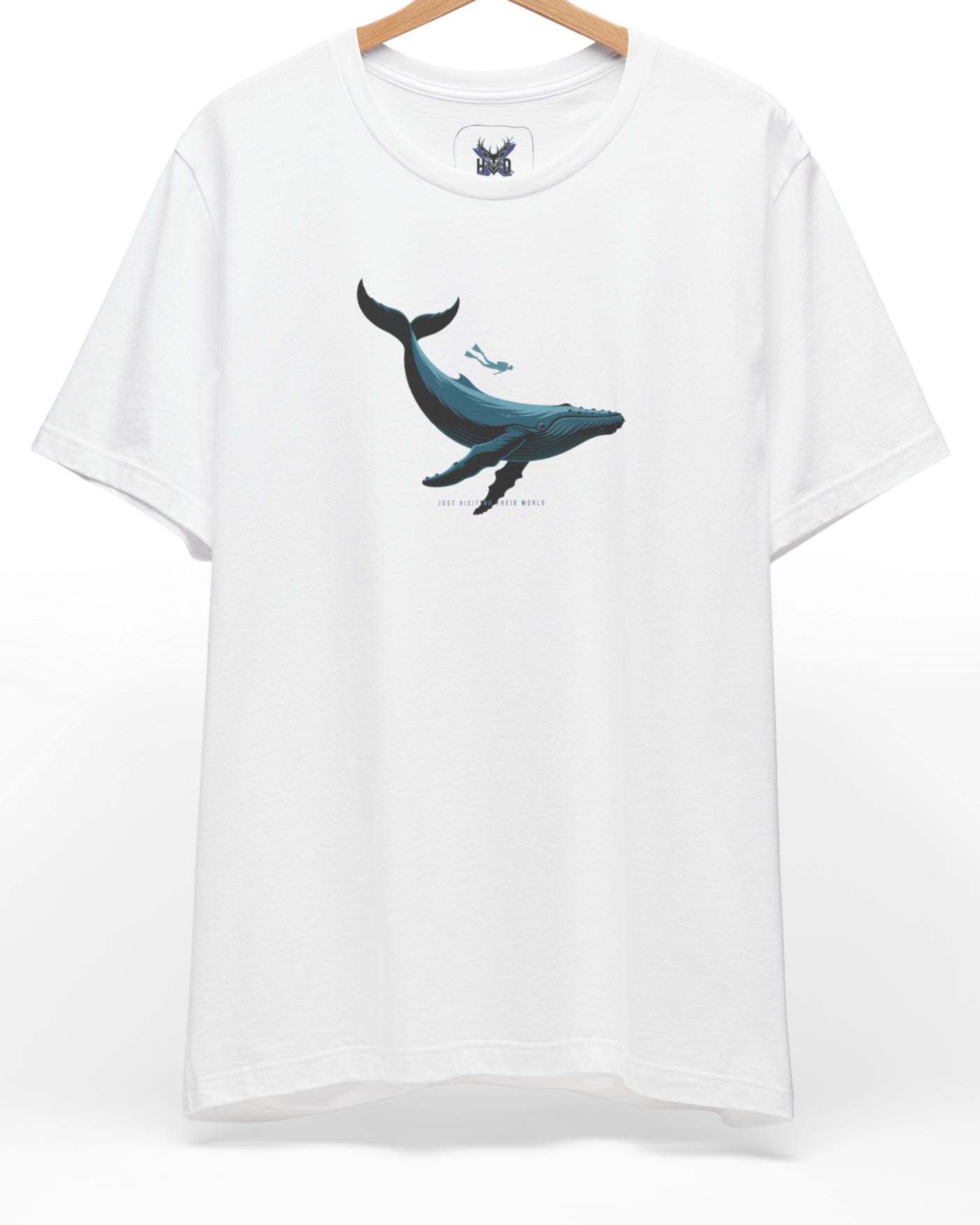 A pristine studio layout displaying the official Holydeer Scuba Diving Whale Shirt suspended from a modern chrome rack. The central artwork highlights a deep navy blue Whale Graphic Tee design swimming alongside a miniature Scuba Diving Shirt diver, creating a premium minimalist look on a white cotton canvas.