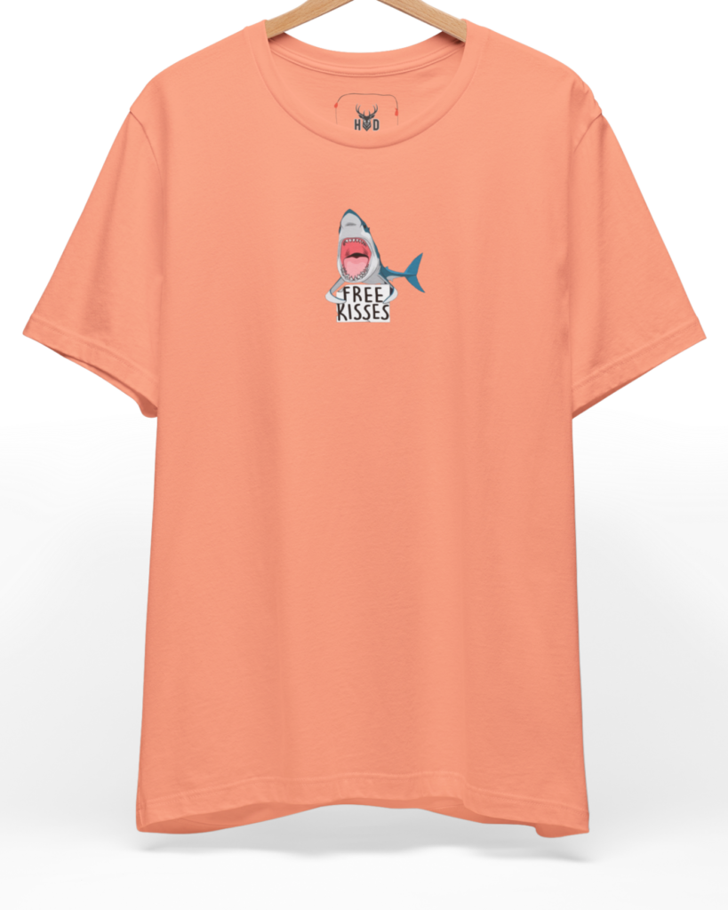 A high-end display of the official Holydeer Shark Graphic Tee showcasing unique Nautical Streetwear design lines. The central Ocean Humor Apparel graphic features a miniature Free Kisses Top layout centering a detailed Apex Predator Shirt shark holding a sarcastic ocean top card printed squarely on a sunset coral shirt canvas.