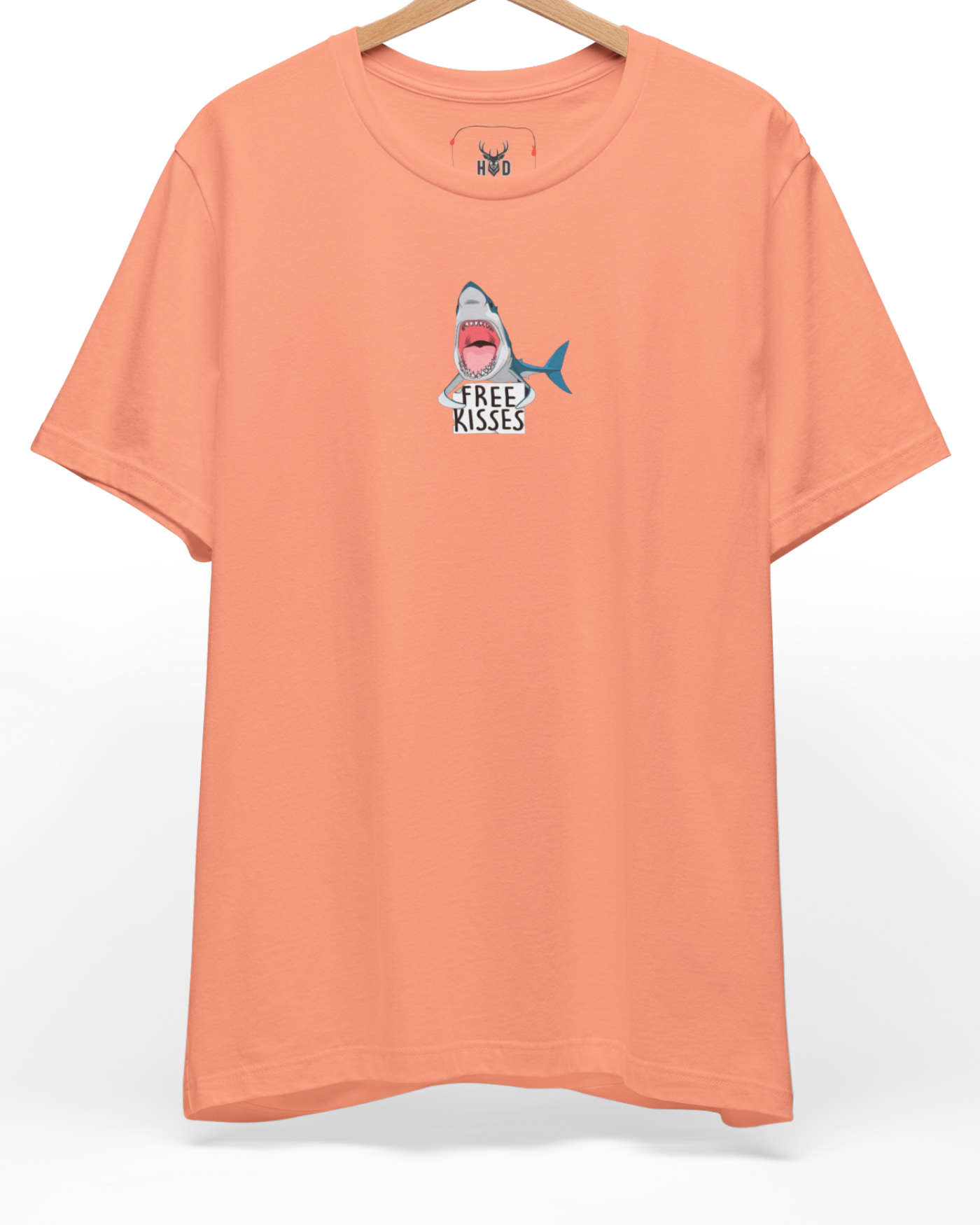 A high-end display of the official Holydeer Shark Graphic Tee showcasing unique Nautical Streetwear design lines. The central Ocean Humor Apparel graphic features a miniature Free Kisses Top layout centering a detailed Apex Predator Shirt shark holding a sarcastic ocean top card printed squarely on a sunset coral shirt canvas.