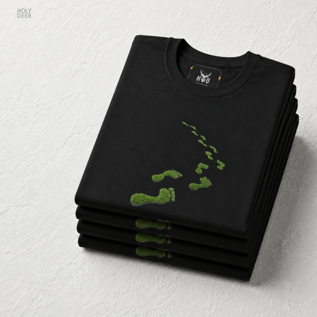 A detailed macro inspection of the Holydeer Clothing Green Steps Shirt focusing entirely on the realistic environmental center print texture. This specific section tracks the delicate desaturated green paint strokes, organic symmetry loops, shadow depths around the toe edges, and dense ink layering forming the core of the eco activist t-shirt symbol.