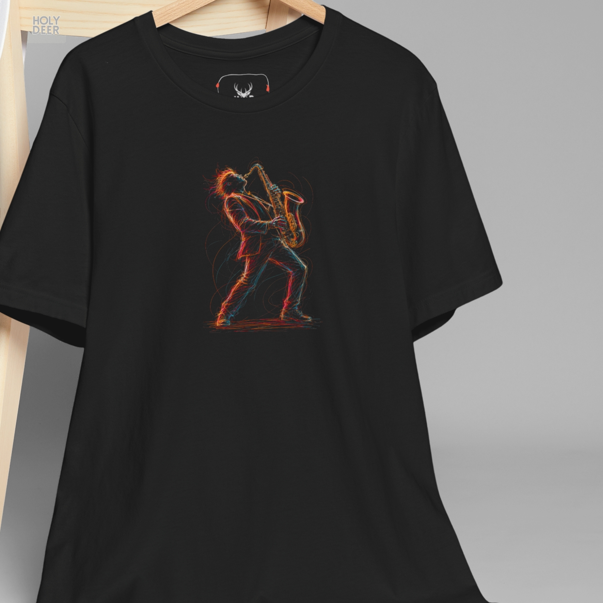 A technical macro view of the Holydeer Tee Saxophone Graphic T capturing the angular neon shadow trails and scattered energetic speed blocks beneath the musician. The frame monitors the clean graphic structure and overlapping color splashes to secure high concert graphic tee layout cohesion, creating a premium presentation for our signature line.