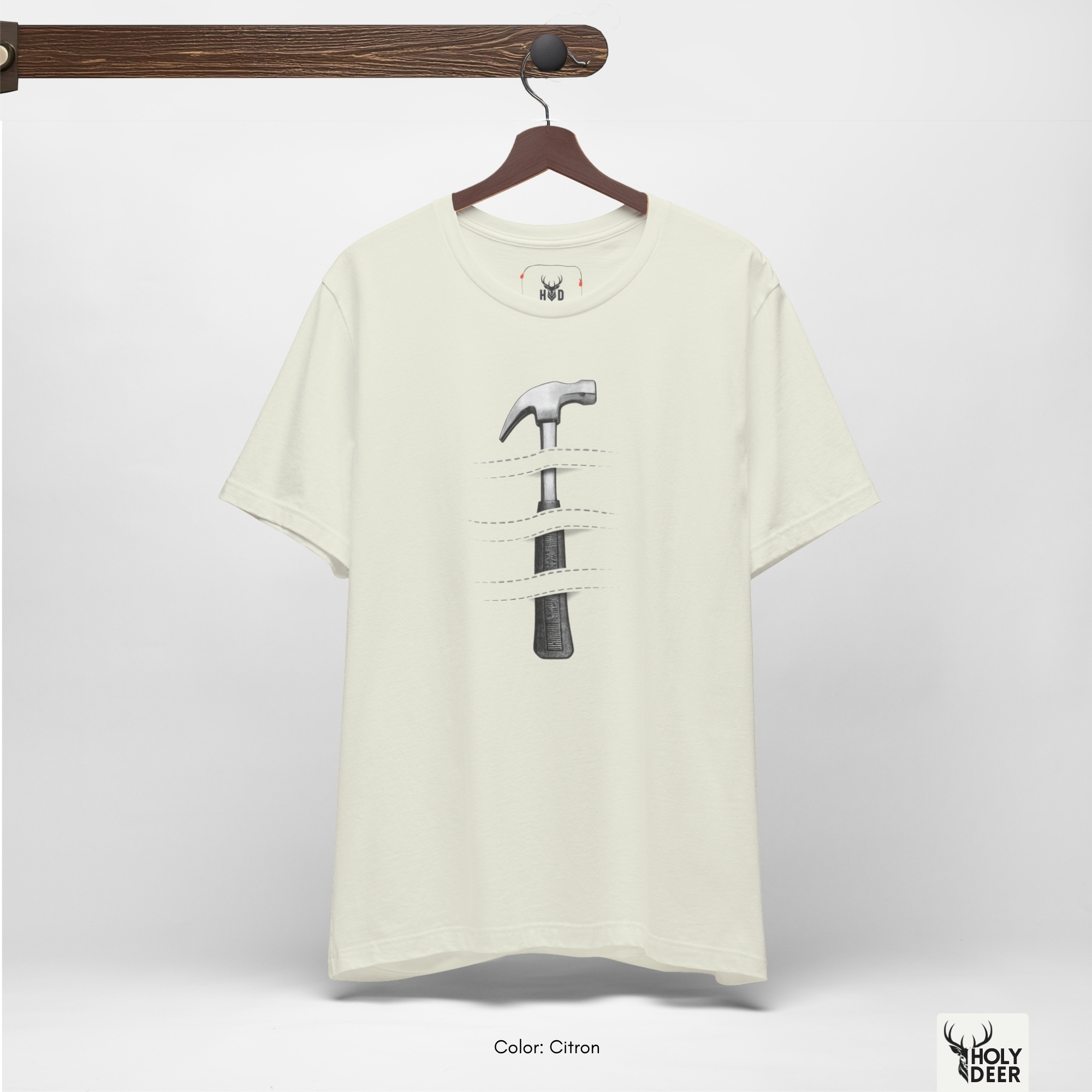 A commercial catalog layout tracking the Holydeer Clothing Hammer Graphic Tee hanging cleanly from a custom timber stand. The product framework documents accurate craftsman gift material behavior, soft chest wrinkles, and balanced square casual fit parameters for high-end boutique distribution.