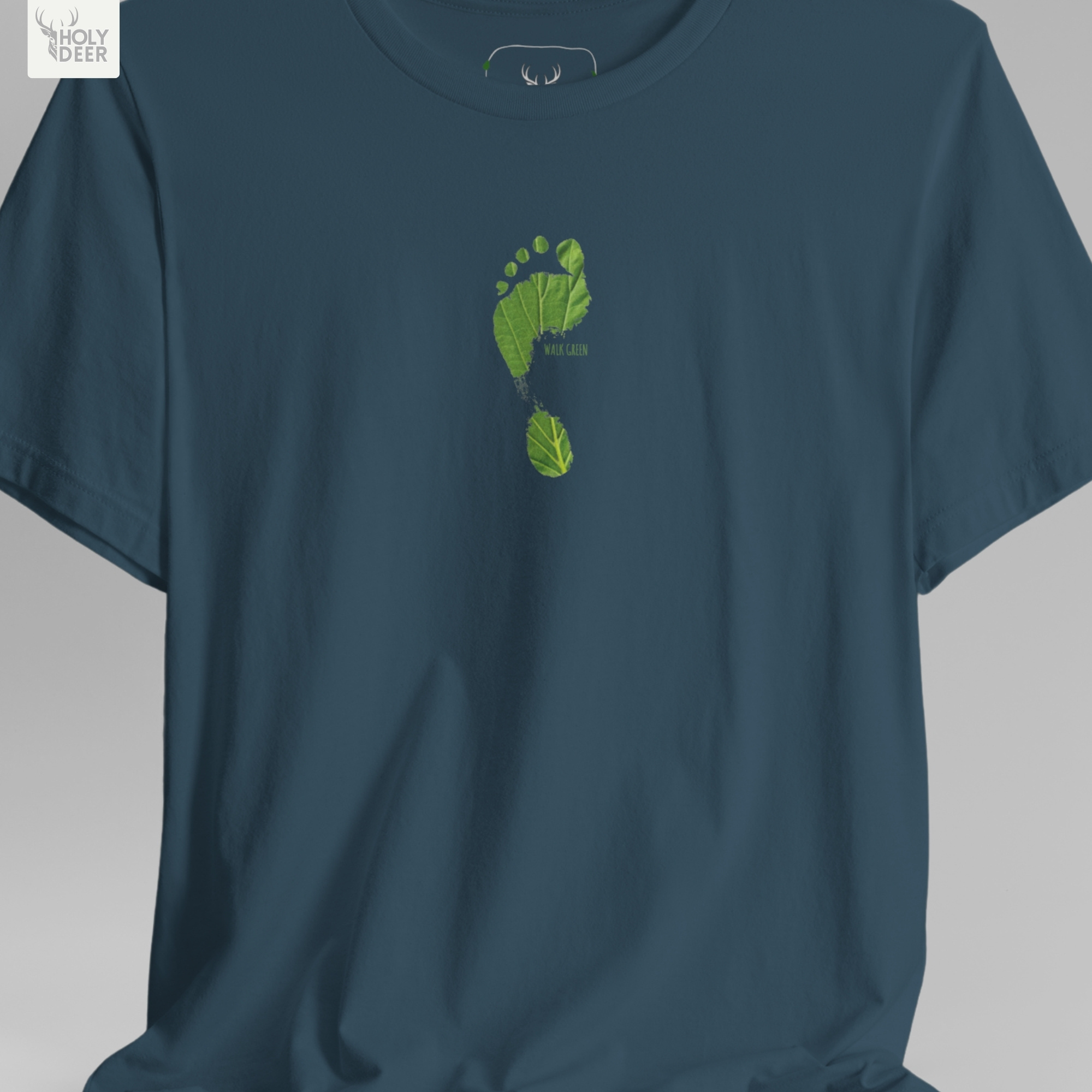 A detailed macro inspection of the Holydeer Clothing Walk Green Tee focusing entirely on the realistic environmental center print texture. This specific section tracks the delicate desaturated green paint strokes, organic symmetry loops, shadow depths around the heel edges, and dense ink layering forming the core of the eco activist shirt symbol.