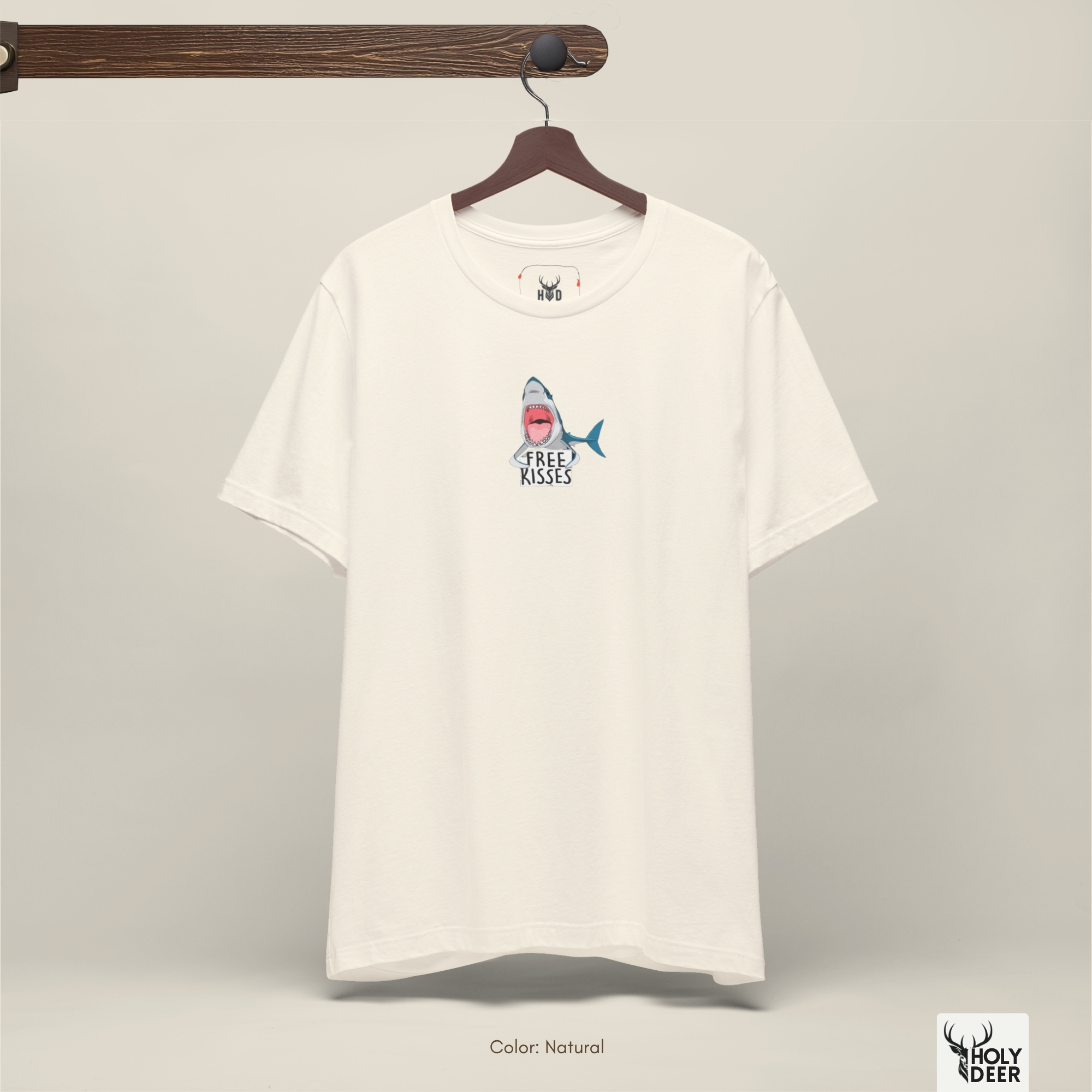 A commercial catalog layout tracking the Holydeer Clothing Shark Graphic Tee hanging cleanly from a custom timber stand. The product framework documents accurate free kisses top material behavior, soft chest wrinkles, and balanced square casual fit parameters for high-end boutique distribution.