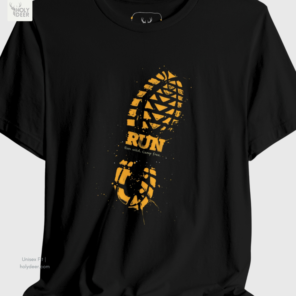 A detailed macro inspection of the Holydeer Clothing Trail Running Tee focusing entirely on the distressed typographic layers. This specific section tracks the solid gold stencil letter borders, the tiny sub-text line reading run wild camp free, and dense screen ink saturation forming the core of the nature explorer tee symbol.