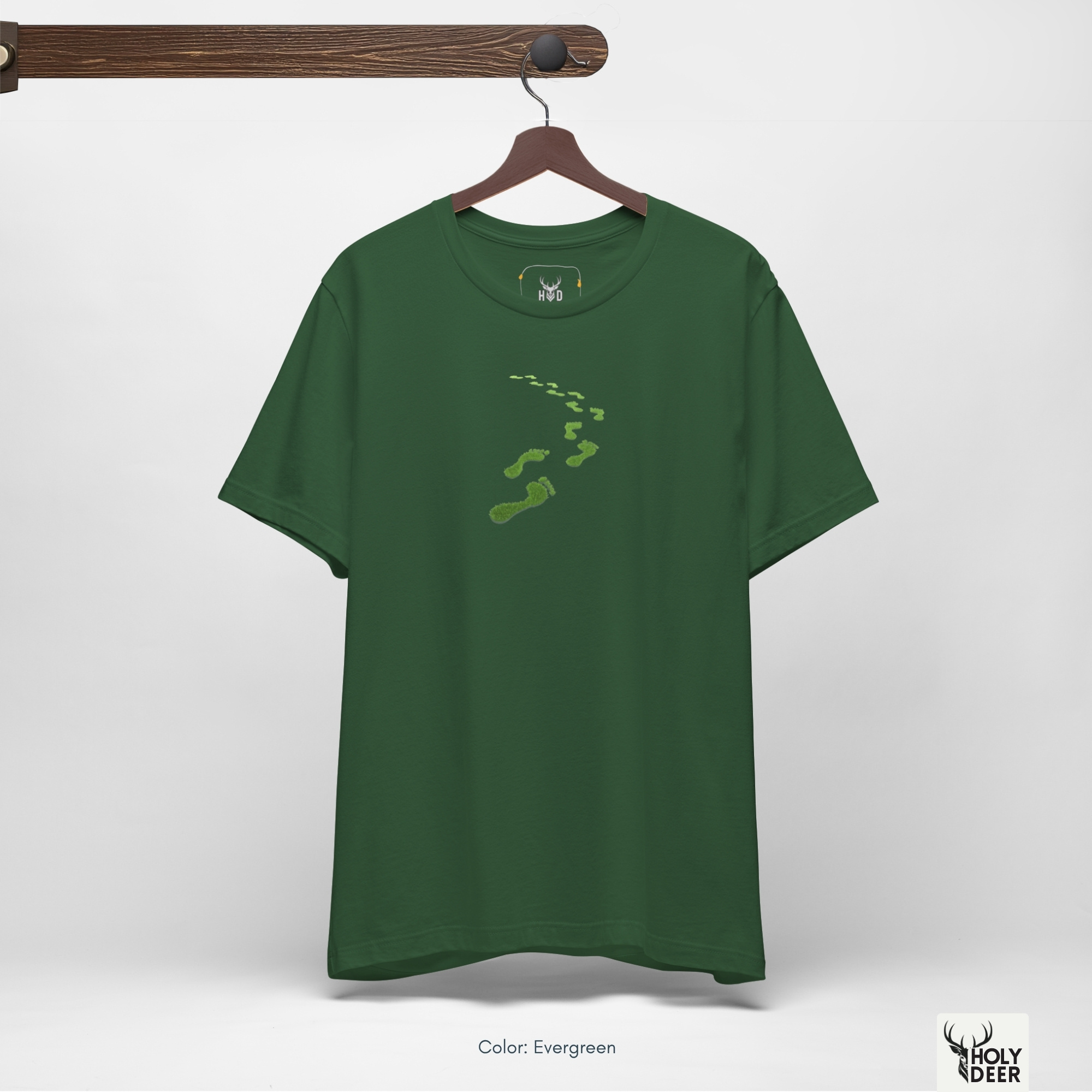 A close showroom catalog viewpoint of the Holydeer Apparel Green Steps Shirt showing the specialized Boutique Activewear printing finish. The framework tracks the tight screen registration of this Sustainability Shirt and Organic Vibe Cloth selection to monitor deep design style rendering, material texturing behaviors, and light reflection.